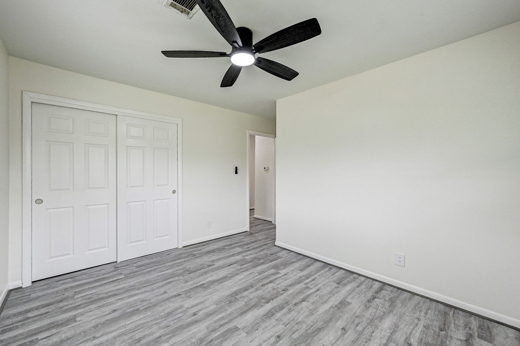 6027 Ledbetter Street Houston, TX 77087 - Photo 18 of 23 an empty room with wooden floor ceiling fan and windows