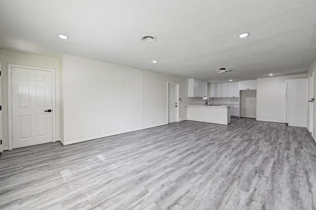 a kitchen with a sink a refrigerator and white cabinets