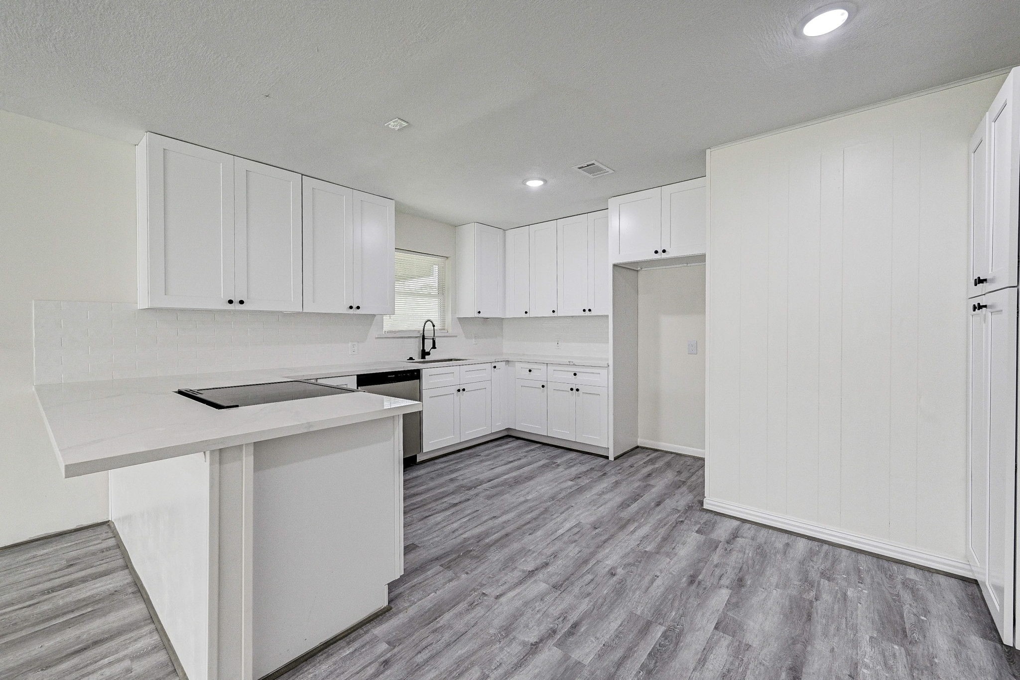 6027 Ledbetter Street Houston, TX 77087 - Photo 7 of 23 a kitchen with a sink a refrigerator and white cabinets