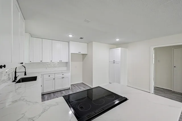 a kitchen with a refrigerator and white cabinets