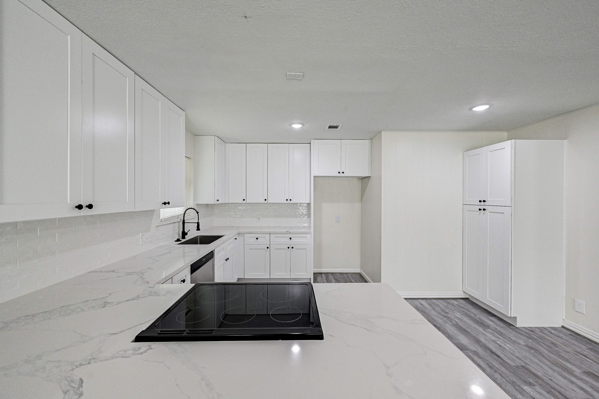 6027 Ledbetter Street Houston, TX 77087 - Photo 9 of 23 a kitchen with a refrigerator and white cabinets