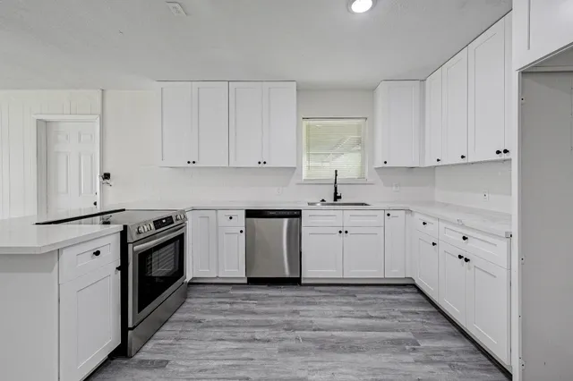 a kitchen with wooden floors and stainless steel appliances