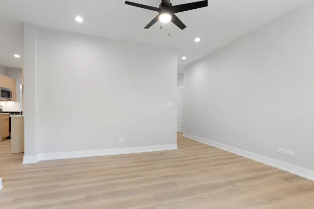 a view of a room with wooden floor and ceiling fan