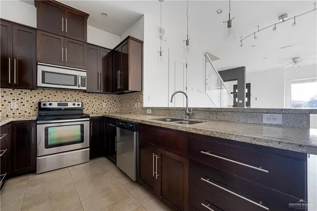 a kitchen with granite countertop cabinets stainless steel appliances and a sink