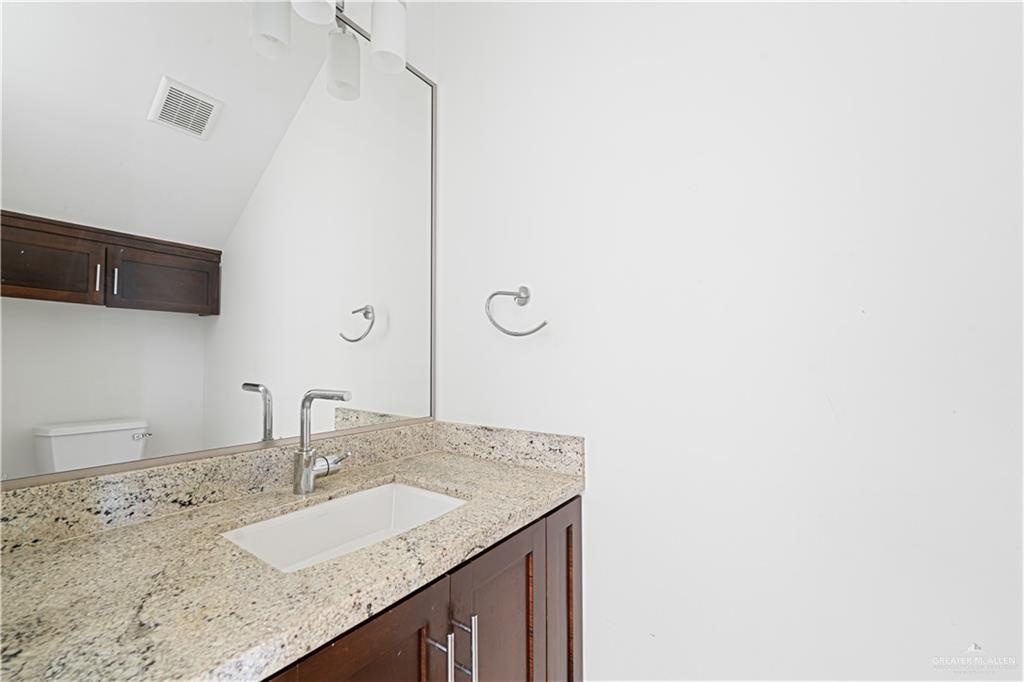 1209 Olympia Avenue, Unit 3 McAllen, TX 78503 - Photo 6 of 21 a bathroom with a granite countertop sink and a mirror