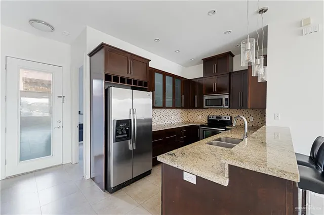 a kitchen with stainless steel appliances granite countertop a refrigerator and a stove top oven
