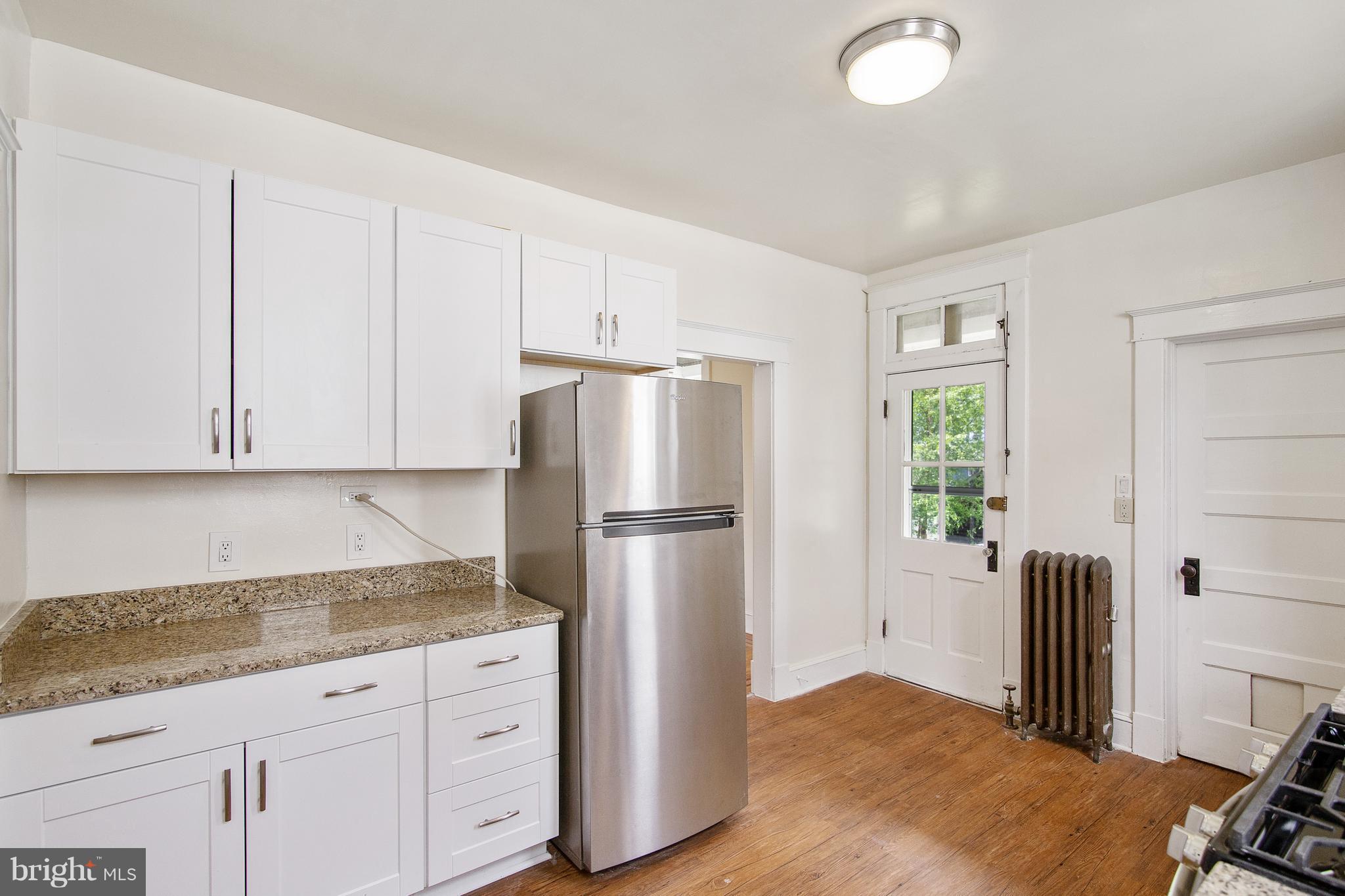 4 Ridge Road Baltimore, MD 21228 - Photo 8 of 21 a kitchen with granite countertop a refrigerator sink and white cabinets