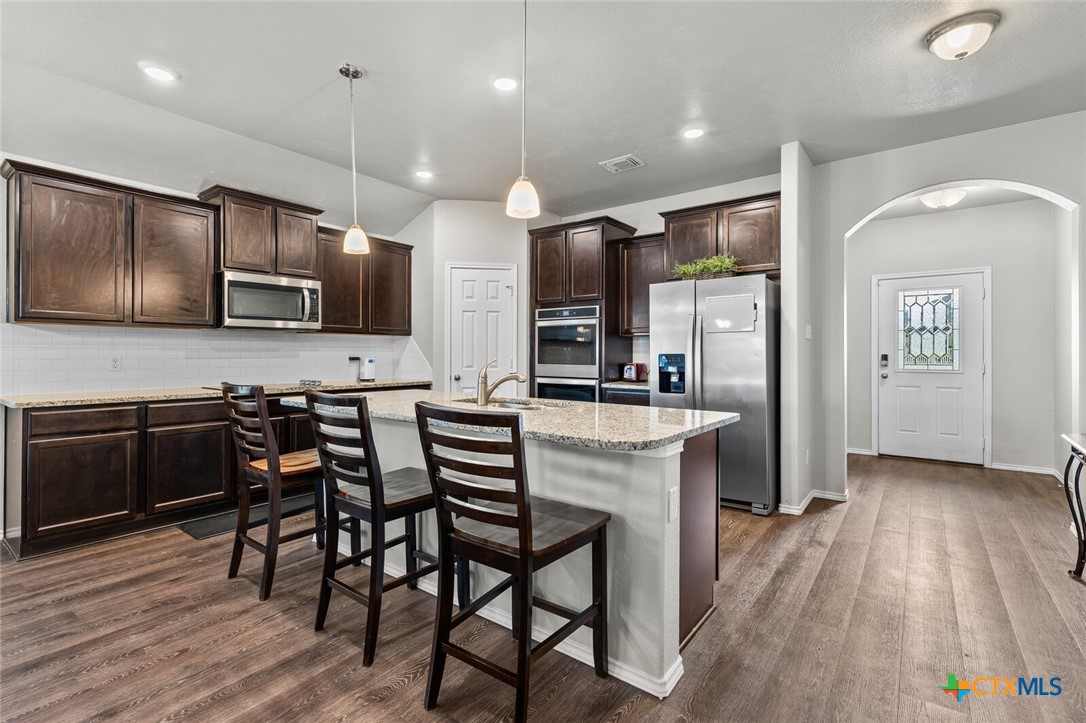 271 Bainbridge Road Temple, TX 76502 - Photo 6 of 36 a kitchen with stainless steel appliances kitchen island granite countertop a stove a sink a refrigerator and a microwave