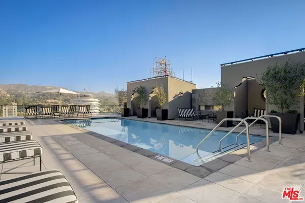 a view of a swimming pool with outdoor seating and city view