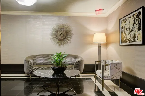 a living room with a black white checkered floor with couches chair and a coffee table
