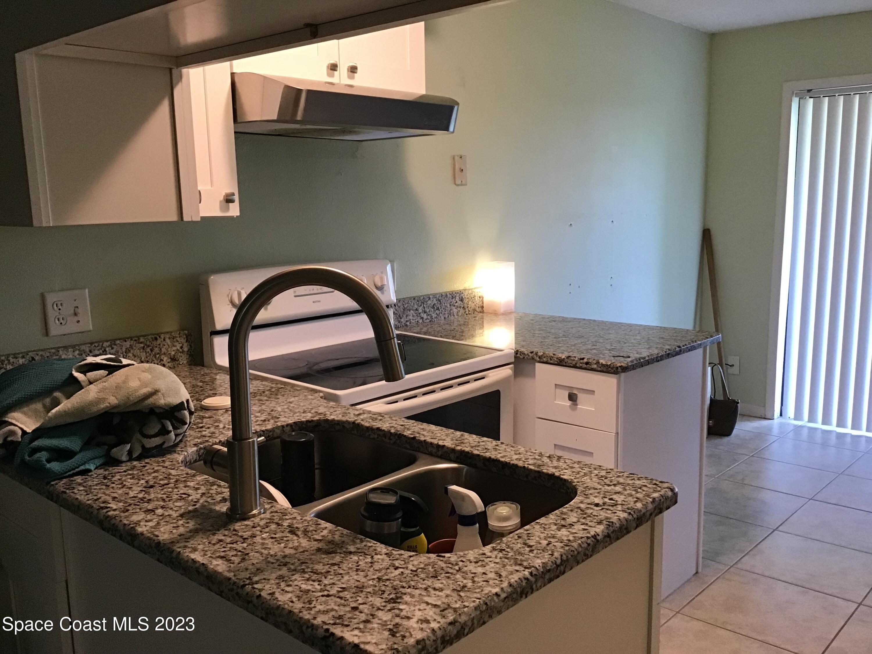 4169 Dividend Avenue Rockledge, FL 32955 - Photo 5 of 12 a kitchen with a sink a stove and cabinets