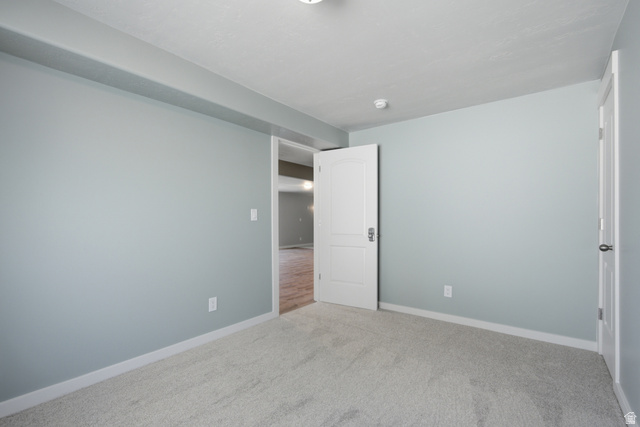 1252 Skyline Road Saratoga Springs, UT 84045 - Photo 40 of 51 Interior room featuring light gray wall paint, light gray carpet, white baseboards, and white trim around doorways