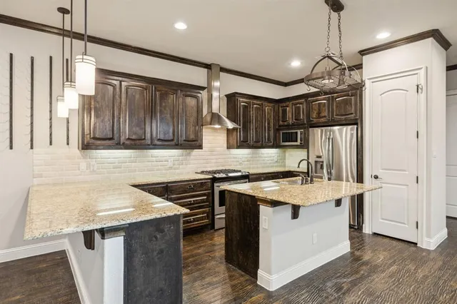 a kitchen that has a sink a stove and a refrigerator
