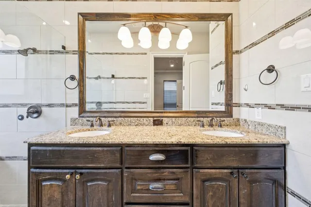 a bathroom with a granite countertop sink vanity and mirror