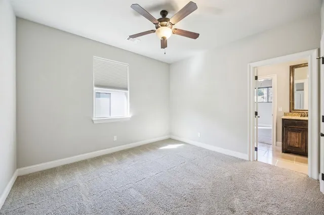 an empty room with closet and a ceiling fan