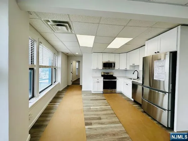 a kitchen with granite countertop appliances a sink and a refrigerator