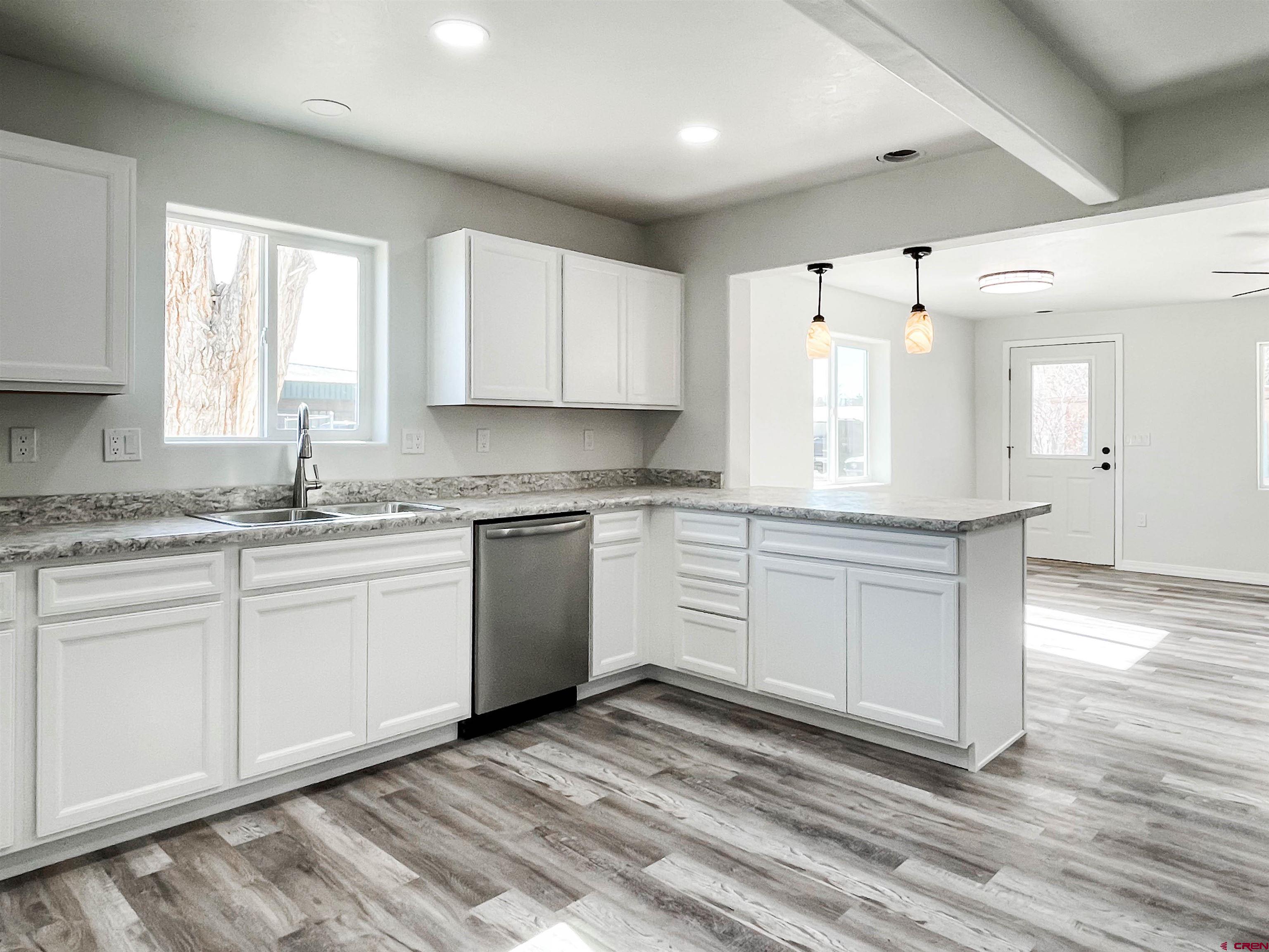554 A Street Delta, CO 81416 - Photo 11 of 33 a kitchen with granite countertop white cabinets white appliances a sink and a window