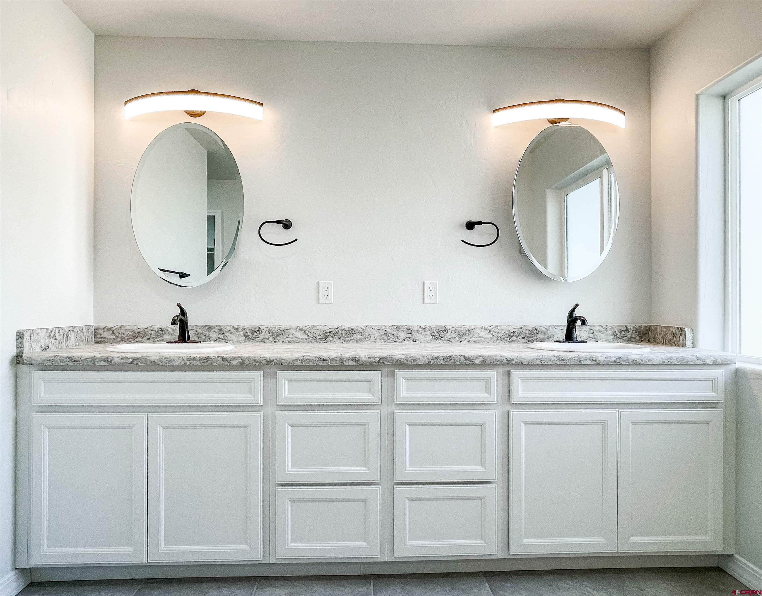 554 A Street Delta, CO 81416 - Photo 20 of 33 a bathroom with a granite countertop double vanity sink and a mirror