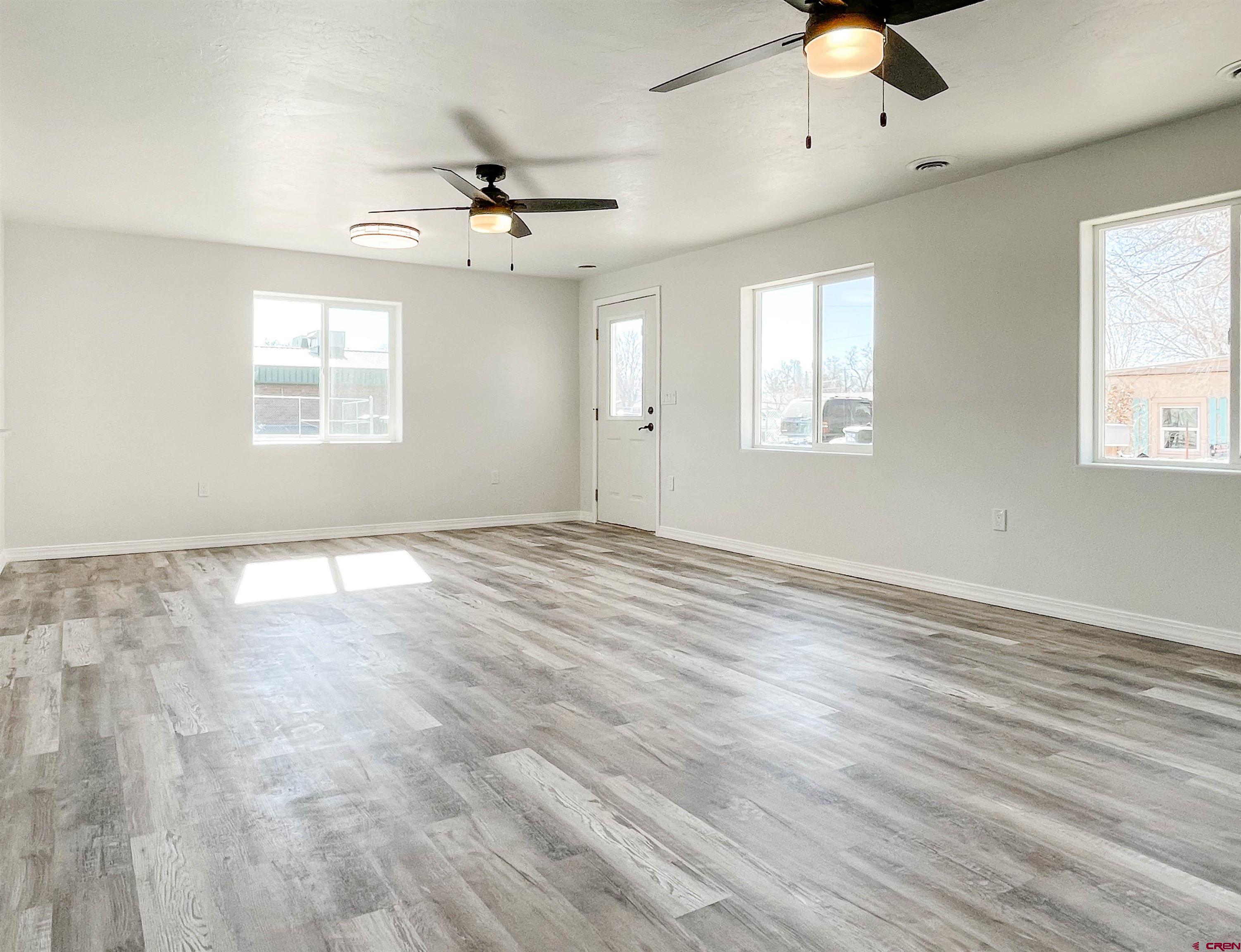 554 A Street Delta, CO 81416 - Photo 4 of 33 an empty room with wooden floor ceiling fan and windows