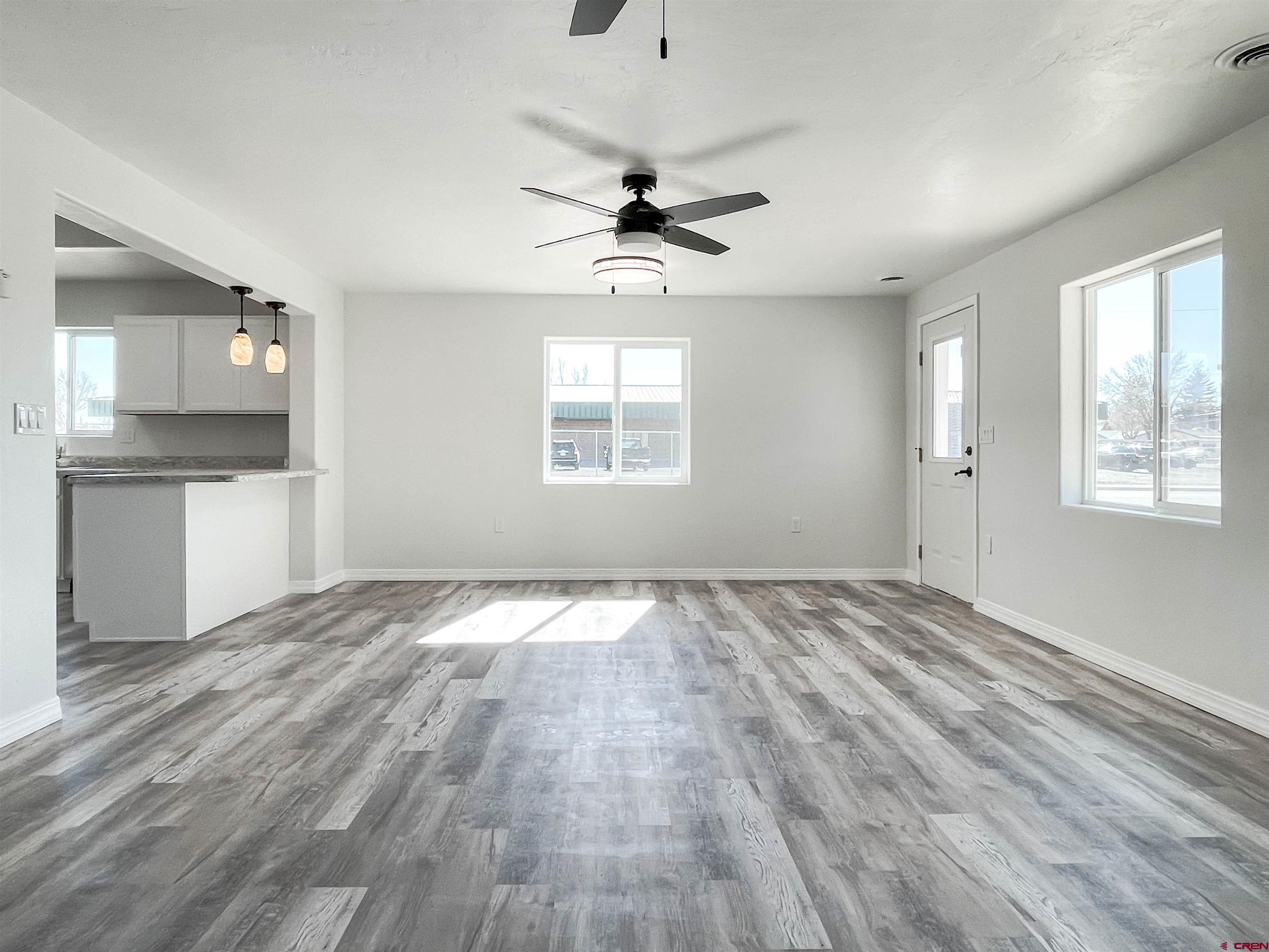 554 A Street Delta, CO 81416 - Photo 6 of 33 an empty room with wooden floor ceiling fan and windows