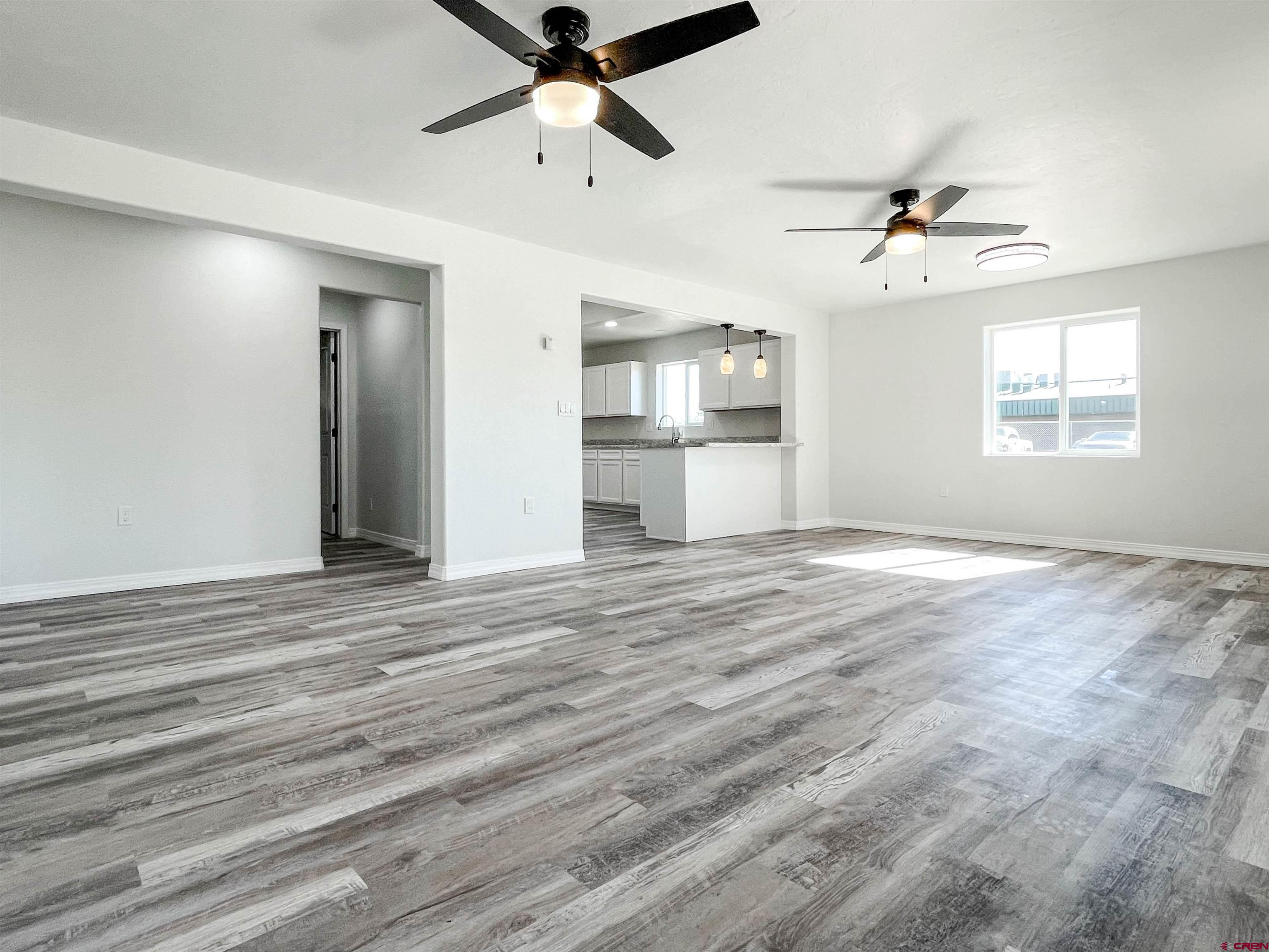 554 A Street Delta, CO 81416 - Photo 7 of 33 an empty room with wooden floor ceiling fan and windows