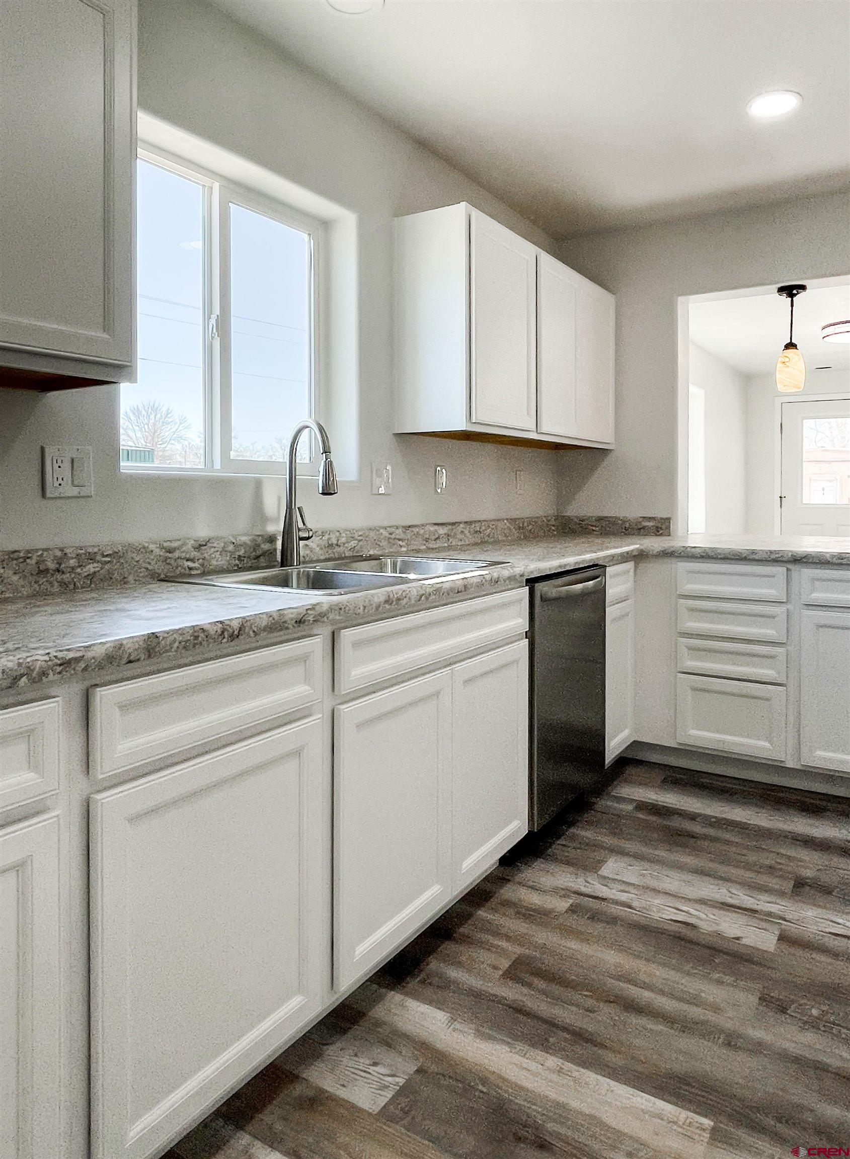 554 A Street Delta, CO 81416 - Photo 10 of 33 a kitchen with white cabinets appliances and a sink