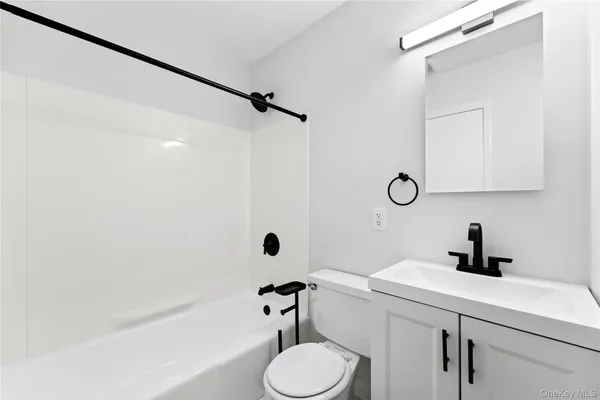 a bathroom with a sink a toilet a mirror and shower