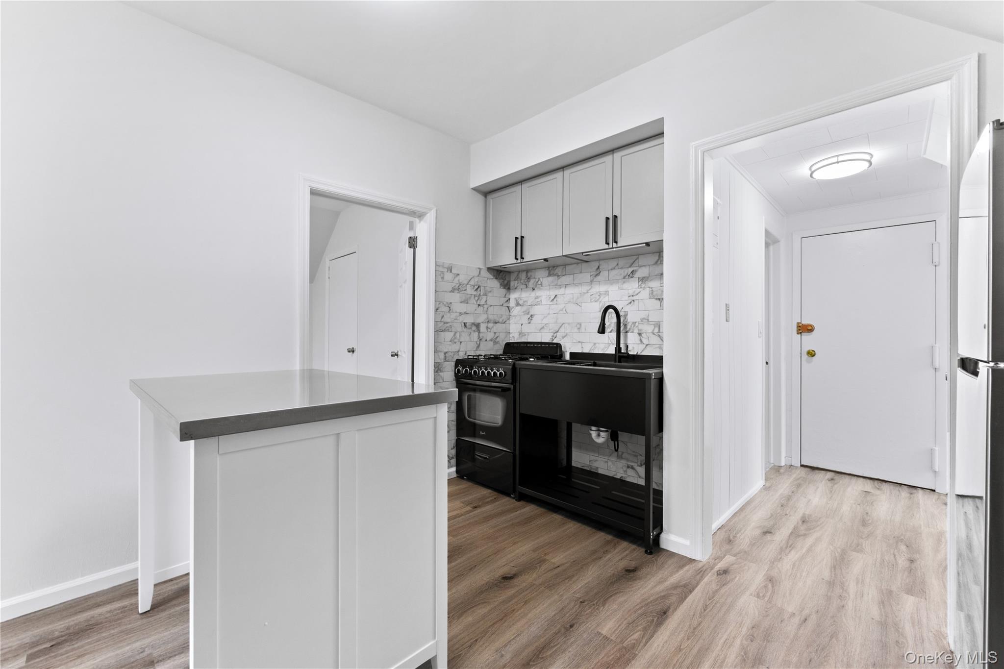 3 Harbor Lane, Unit 3A New Rochelle, NY 10805 - Photo 6 of 16 a kitchen with stainless steel appliances cabinets and wooden floor
