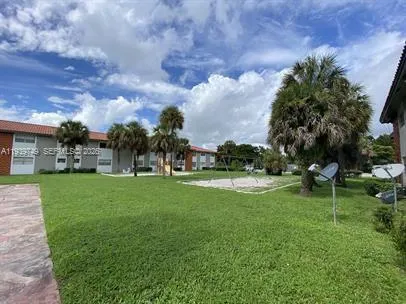 a view of a house with a big yard and a large trees