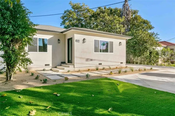 a backyard of a house with table and chairs