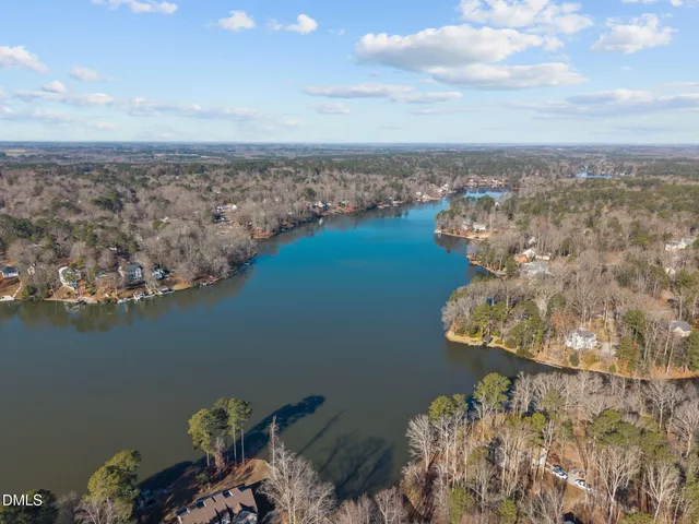 a front view of a house with garden and trees