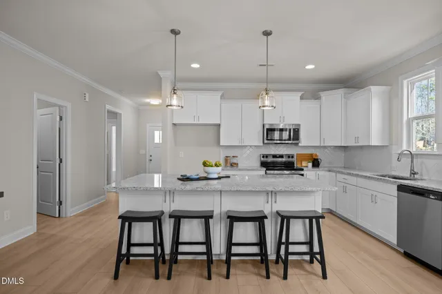 a view living room with kitchen island stainless steel appliances furniture a chandelier and living room view