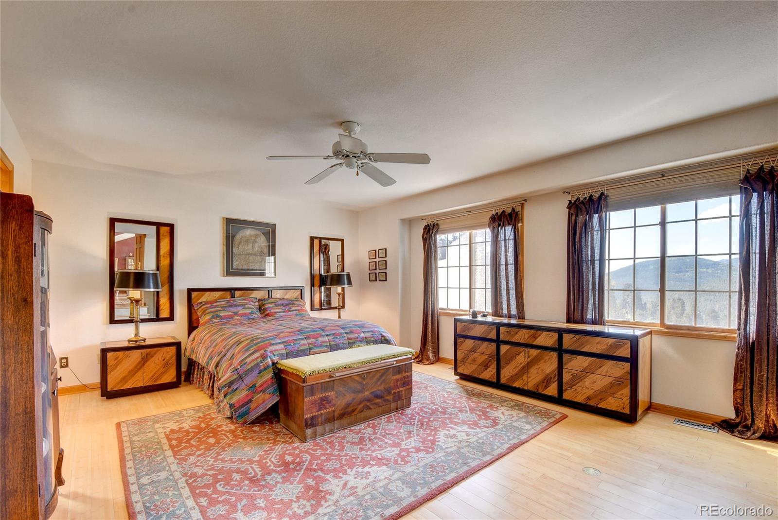 33633 Elk Run Evergreen, CO 80439 - Photo 25 of 40 a spacious bedroom with a large bed and a chandelier