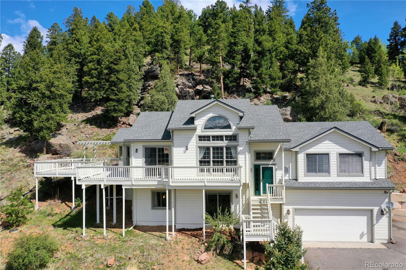 33633 Elk Run Evergreen, CO 80439 - Photo 39 of 40 a view of a white house with large windows and a small yard