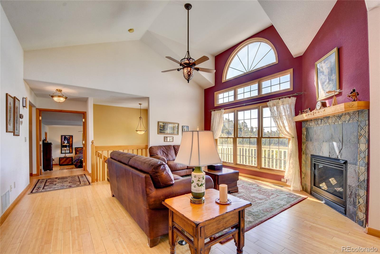 33633 Elk Run Evergreen, CO 80439 - Photo 10 of 40 a living room with furniture a fireplace and a floor to ceiling window