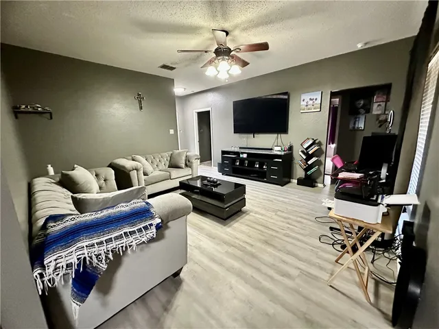 a living room with furniture a flat screen tv and a fireplace
