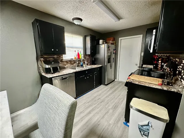 a kitchen with a table chairs refrigerator and stove