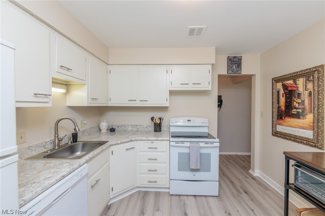 1750 Wagar Road, Unit 206 Rocky River, OH 44116 - Photo 14 of 33 Kitchen featuring white appliances, light LVP flooring, light countertops, and white cabinetry