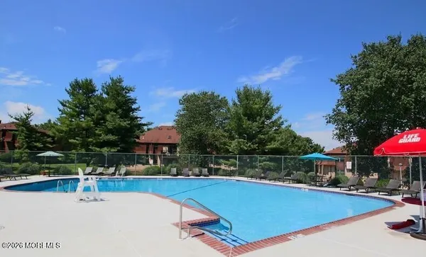 a view of a swimming pool with a table and chairs under an umbrella