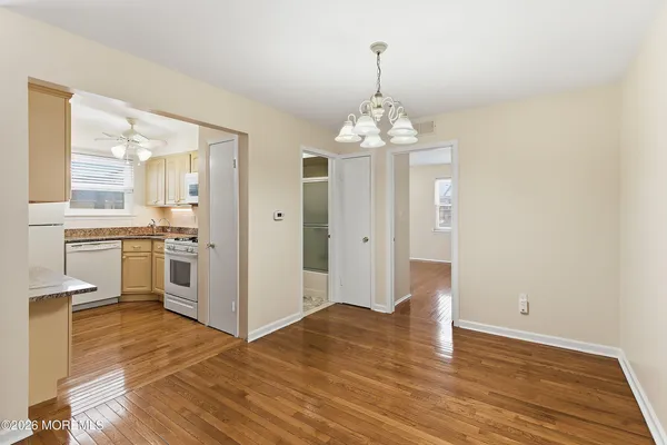 a view of a kitchen with a sink dishwasher a refrigerator and wooden floor
