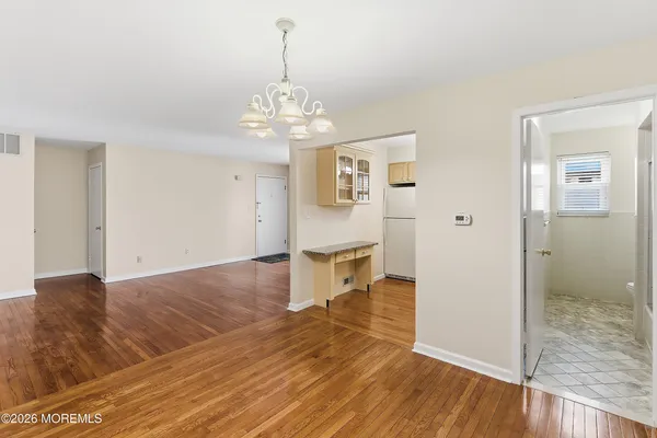 a view of a hallway with wooden floor and chandelier