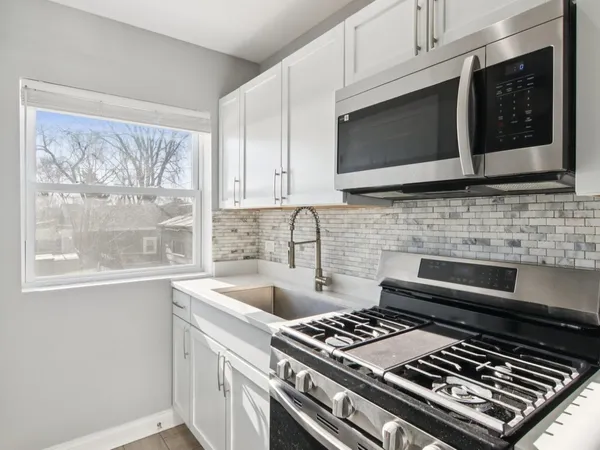a kitchen with stainless steel appliances a stove a microwave a sink and cabinets
