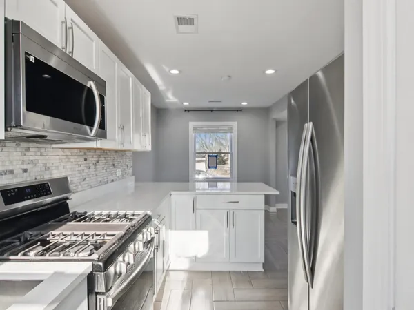 a kitchen with stainless steel appliances granite countertop a stove microwave and refrigerator