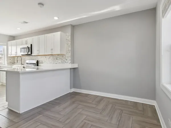 a kitchen with kitchen island white cabinets and white appliances