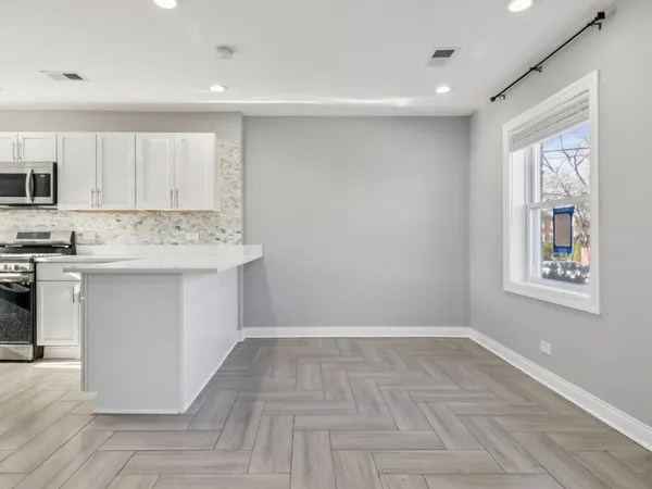 a view of kitchen with cabinets and window