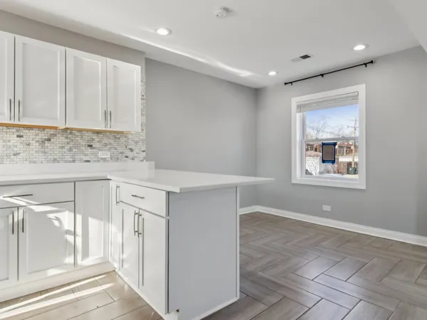 a kitchen with granite countertop white cabinets and white appliances