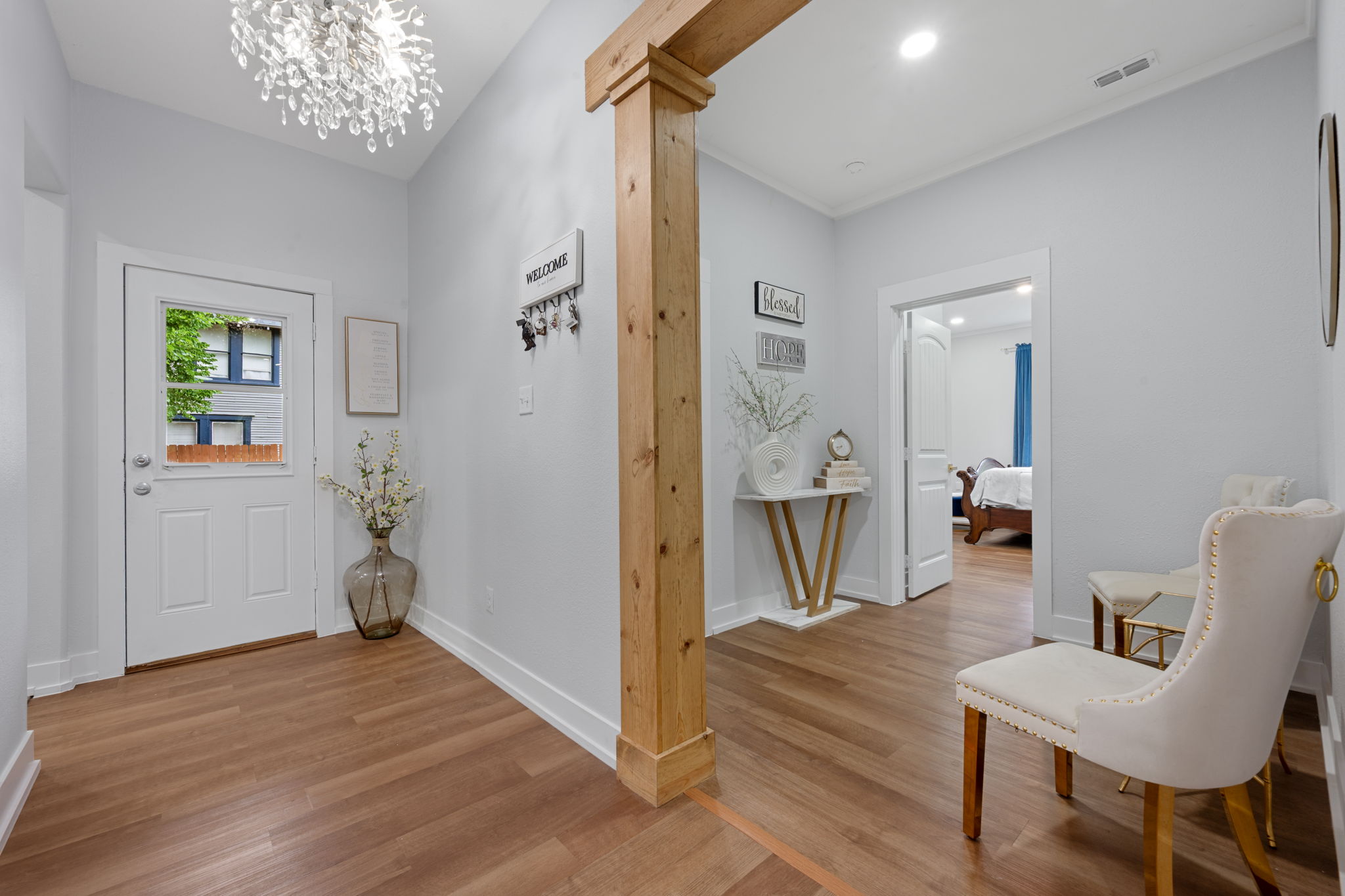 602 East 6th Street Cameron, TX 76520 - Photo 23 of 40 Foyer featuring wood-finish flooring, a white paneled entry door with frosted glass, and a prominent wood structural beam