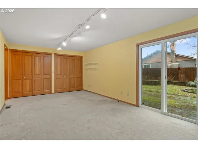 en empty room with sliding door and wooden floor
