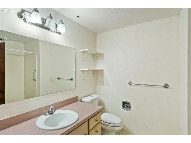 a bathroom with a sink toilet a mirror and shower