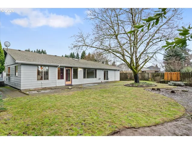 a backyard of a house with table and chairs